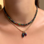 Shag carpet faceted opal necklace layered with a bead chain necklace with labradorite drop charm and ruby zoisite drop charm on the neck.