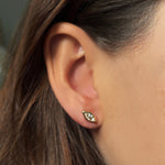 Single molten solitaire stud earring with a marquise diamond in yellow gold on the ear. 