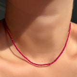 Ruby faceted slim gemstone necklace on a model's neck.