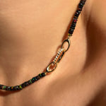 Small diamond charm lock in the clasp of a black faceted opal necklace.