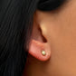 Liquid yellow gold stud earring on model ear