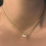 Sprinkle chain in 14k yellow gold with molten solitaire charm with marquise diamond on a model's neck.