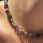 Triple link charm lock in white gold on a rutilated quartz collar with neon red thread.