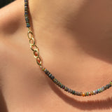 triple link charm lock attached to an opal necklace worn on the neck