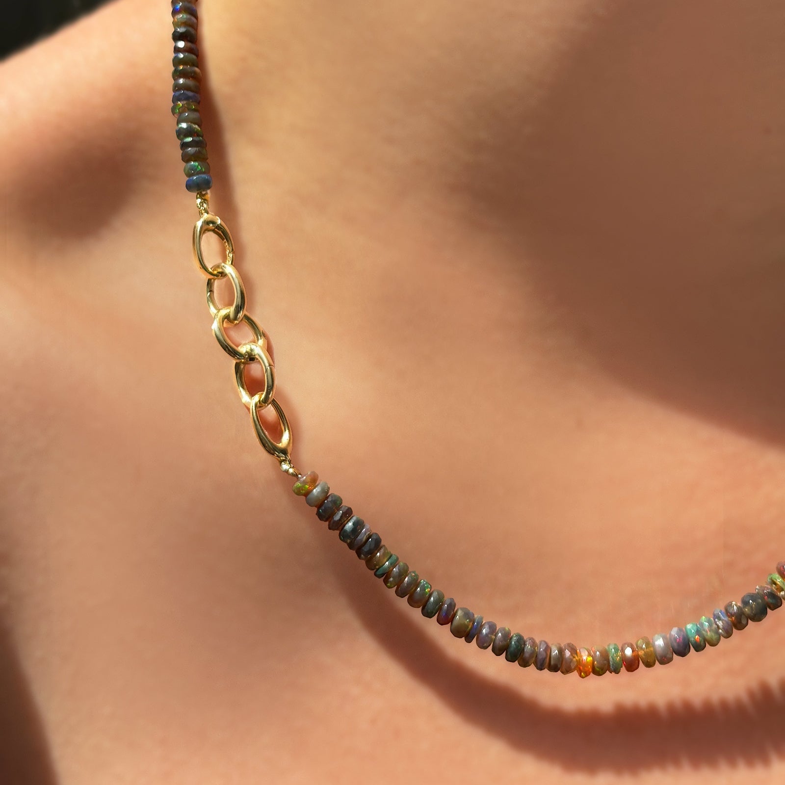triple link charm lock attached to an opal necklace worn on the neck