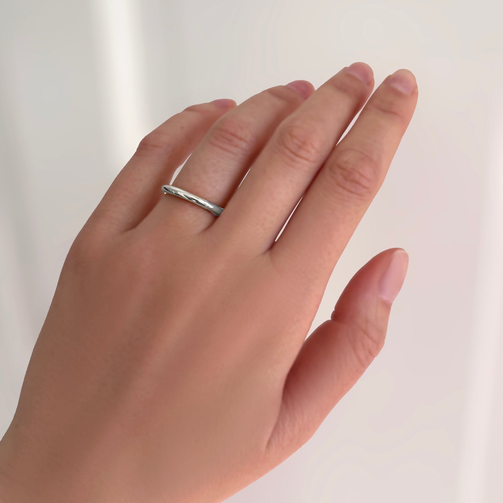 AMANDA PEARL molten band in recycled 14k gold on a model's hand.