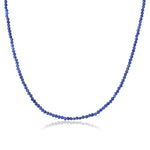 Shimmering slim gemstone beaded necklace made of 2mm faceted stones in Lapis on a gold linking lobster clasp on a white background 